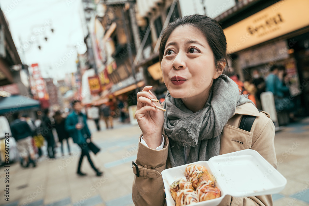 美丽的亚洲女人带着可爱的微笑吃高汤。可爱的女士旅行者参观筑天阁并享受