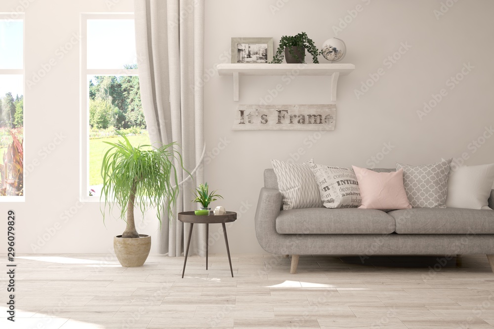 Stylish room in white color with sofa and summer landscape in window. Scandinavian interior design. 