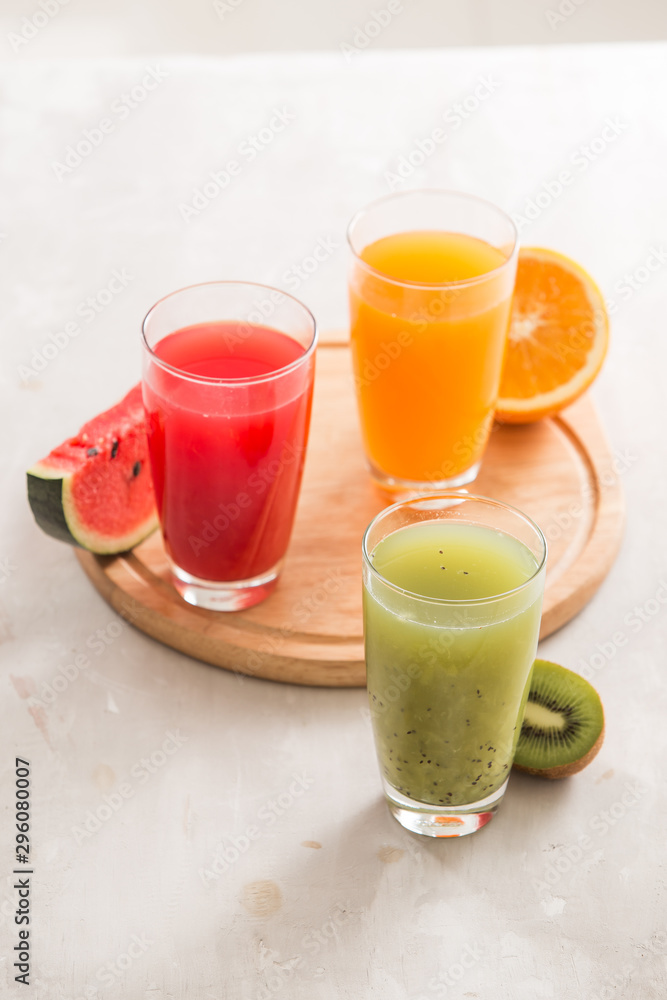 Fresh juices smoothie three glass red green orange tropical fruits water melon, kiwi, orange. Select