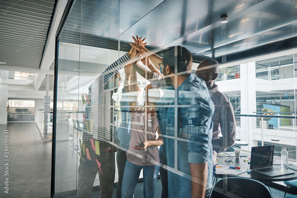 Cheering businesspeople high fiving together after an office bra