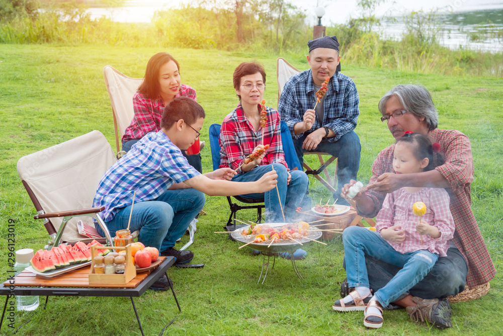 Happy asian family camping and enjoy with Bar-B-Q together at camping site.