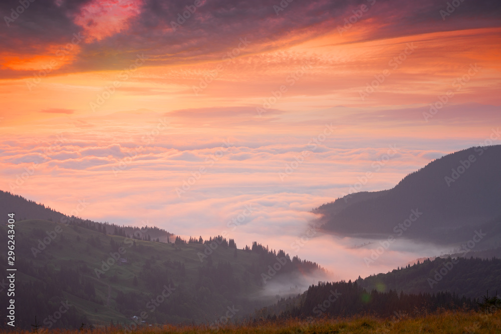 Mountain peaks above the clouds at sunset