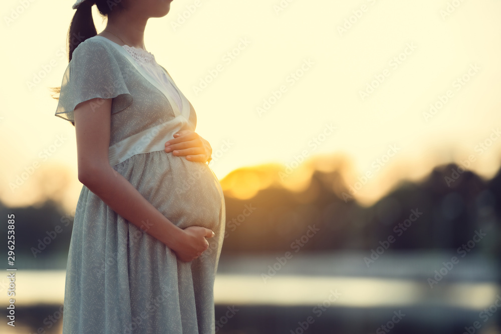 Pregnant woman walks in the park she feels relaxed