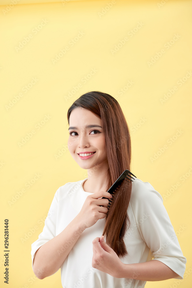 young beautiful woman combing her hair in living room