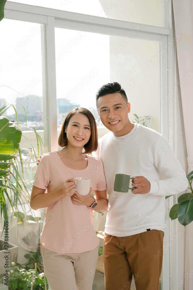 happy couple relaxing together at home with cup of coffee