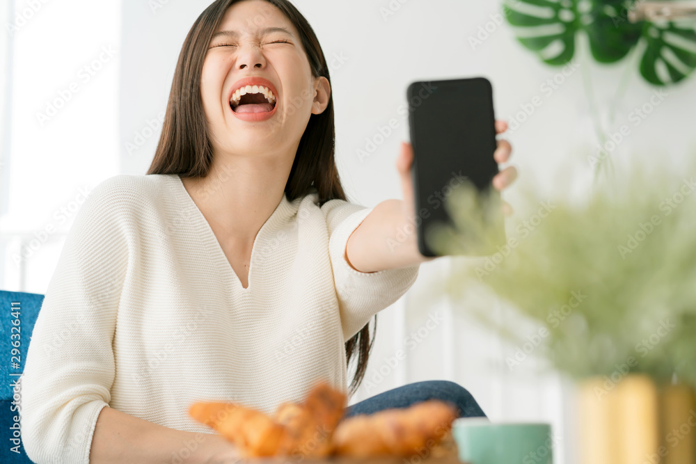 美丽的亚洲女人享受周末手持智能手机在社交媒体上与幸福交流