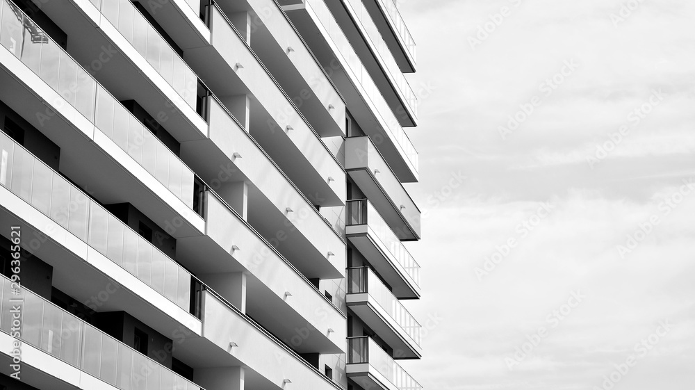  Fragment of a facade of a building with windows and balconies. Modern home with many flats. Black a