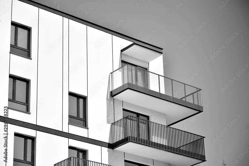  Fragment of a facade of a building with windows and balconies. Modern home with many flats. Black a