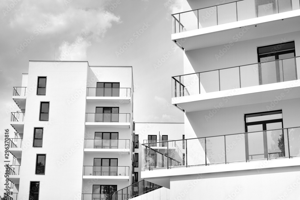 Fragment of a facade of a building with windows and balconies. Modern home with many flats. Black an