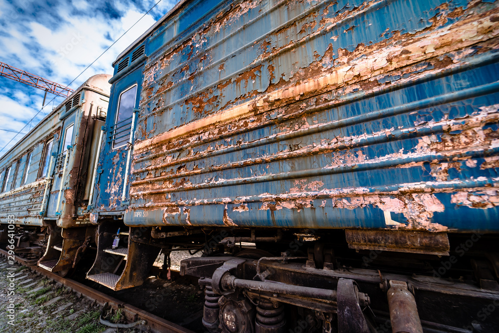 old rusty weathered peeled paint of an old wagon. Blue abandoned railway carriage. Old railwaystatio