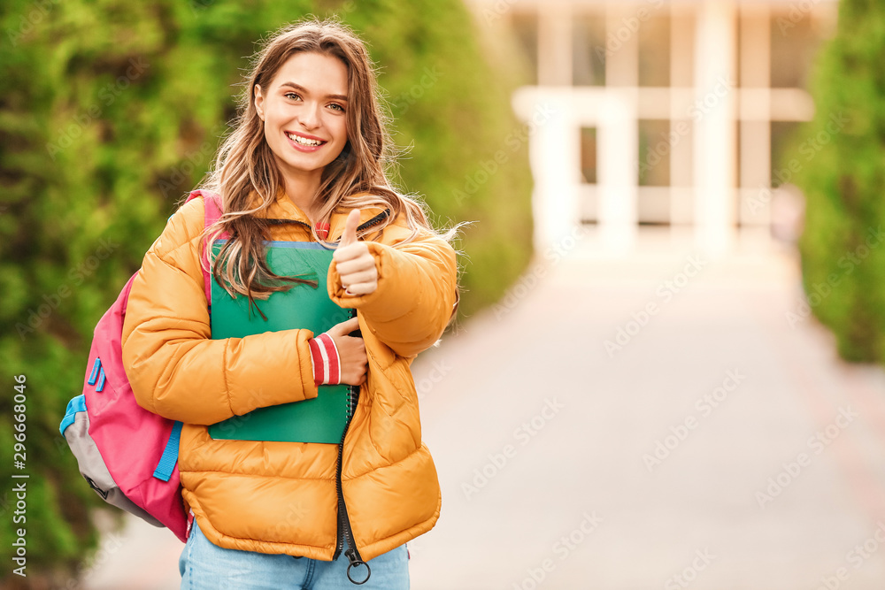 青少年女学生在户外竖起大拇指的肖像