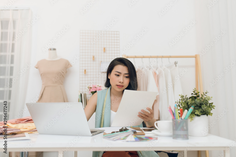 A business woman / Asian fashion designer working at her office / workshop