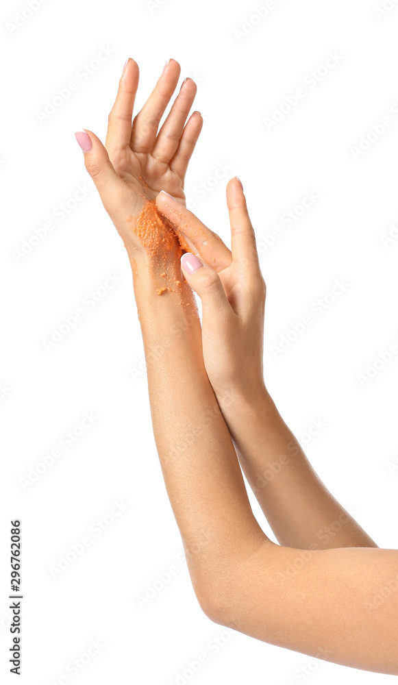 Beautiful young woman applying body scrub against white background