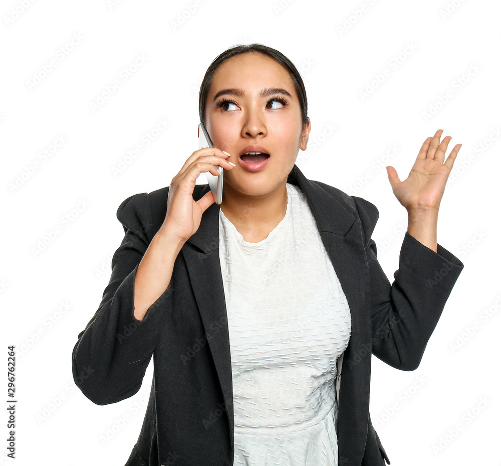 Portrait of surprised Asian businesswoman talking by mobile phone on white background