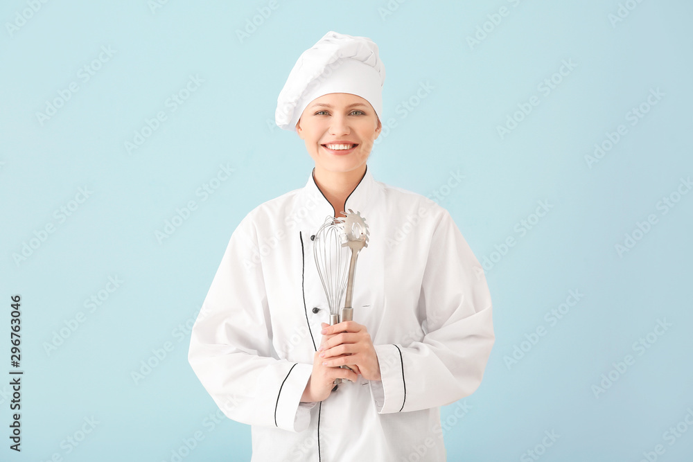 Beautiful female chef with kitchenware on light background