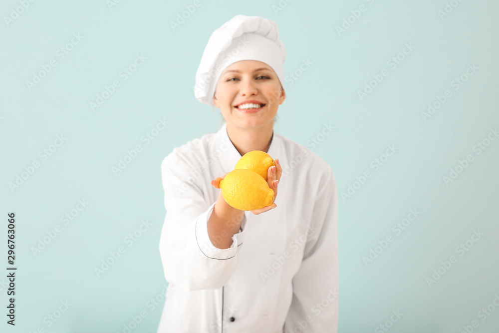 Beautiful female chef with lemons on light background