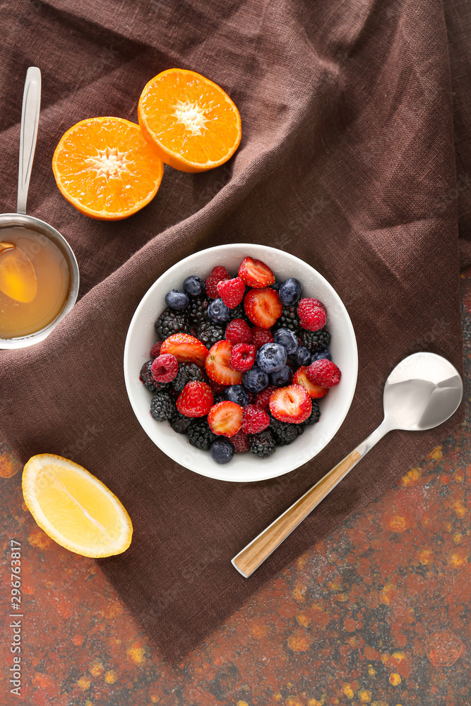 Bowl with tasty fruit salad on color background