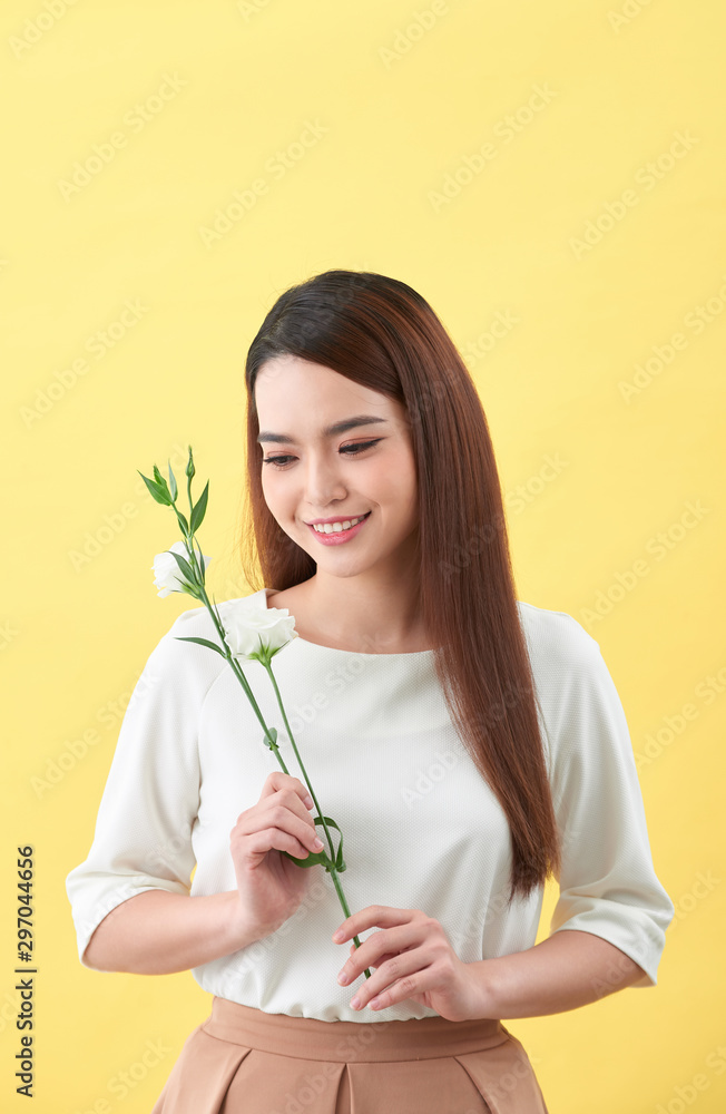 一位手持鲜花的迷人年轻女子的特写肖像