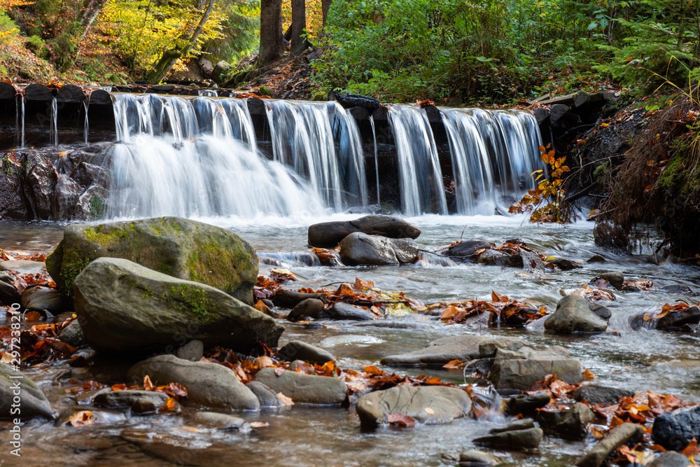 Colorful majestic waterfall in autumn forest