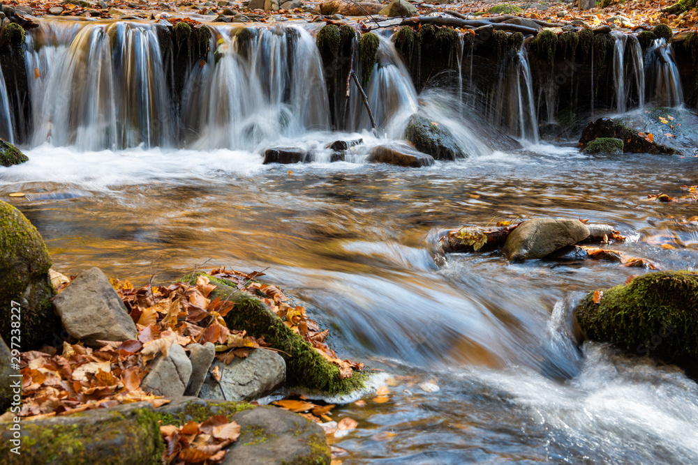 Colorful majestic waterfall in autumn forest