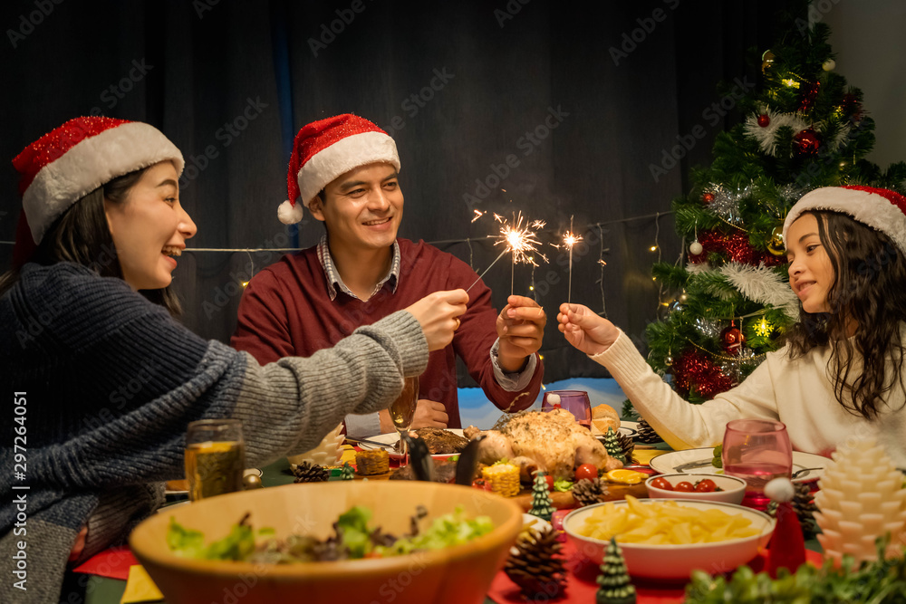 幸福的家庭，父亲、母亲和女儿，一起共进晚餐庆祝圣诞节