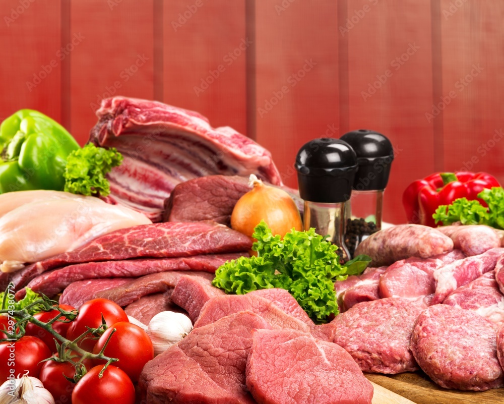 Fresh raw meat with vegetables on brown wooden table at wooden background