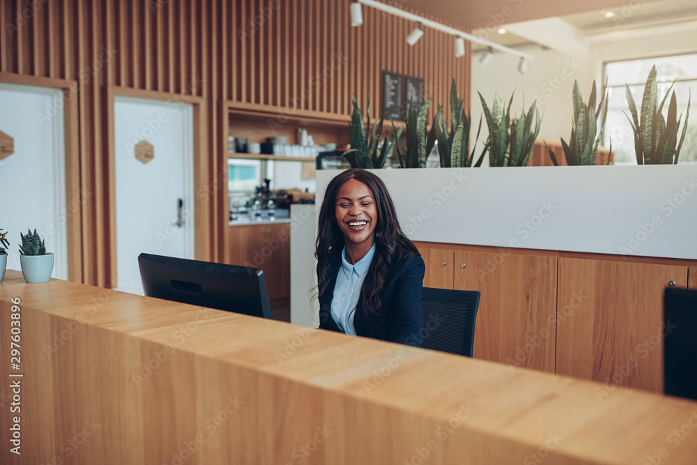 Laughing African American businesswoman working at a reception d