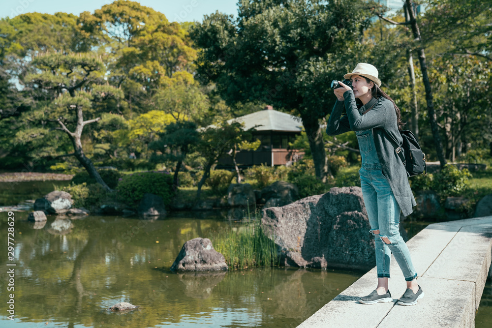 年轻漂亮的女士摄影师在公园里拍摄风景。优雅女人的全长