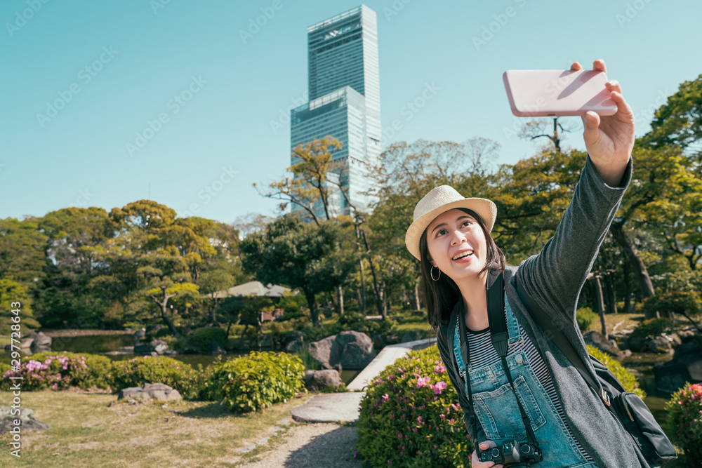 happy traveler woman making selfie on background Abeno ku area in osaka city. young girl smiling tak