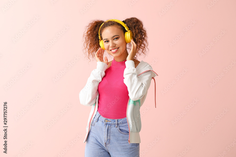 Beautiful African-American woman listening to music on color background