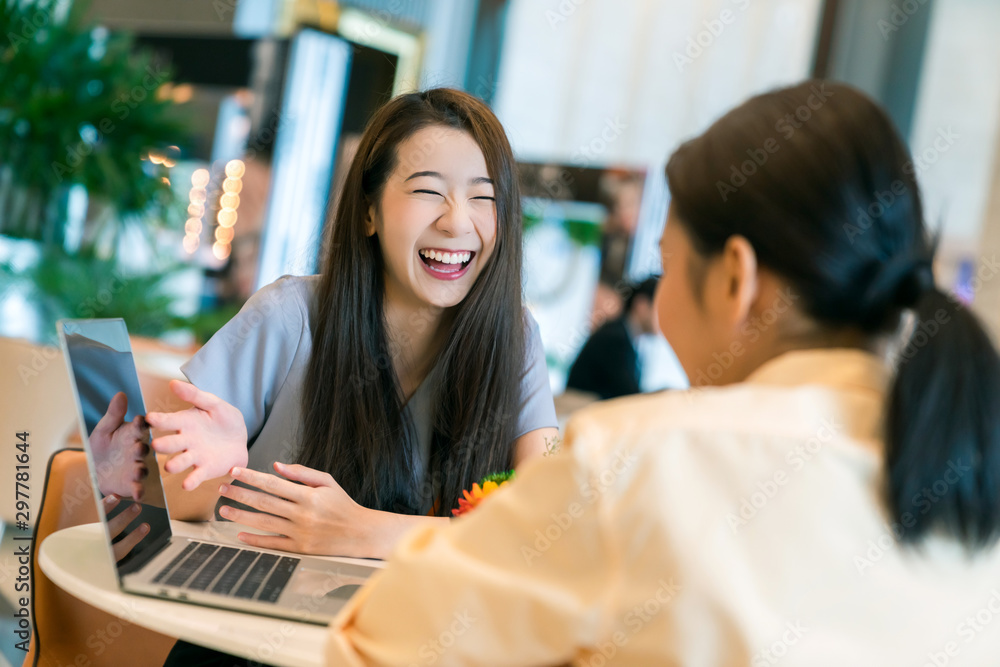 美丽迷人的商务女性用笔记本电脑向客户微笑和快乐地展示新项目