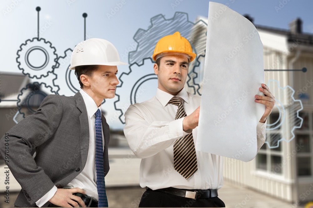 Two engineers men at construction site watching blueprint