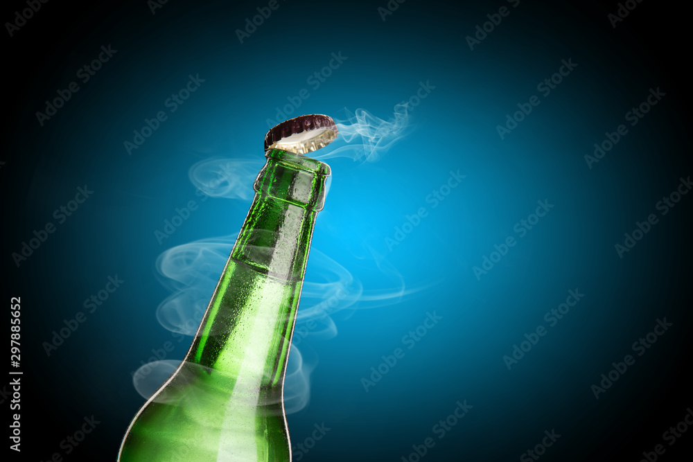 Cold wet bottle of chilled drink with drops. Opening of beer cap with the gas output.