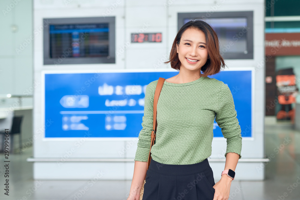 Travel. Young woman goes at airport at window with suitcase waiting for plane