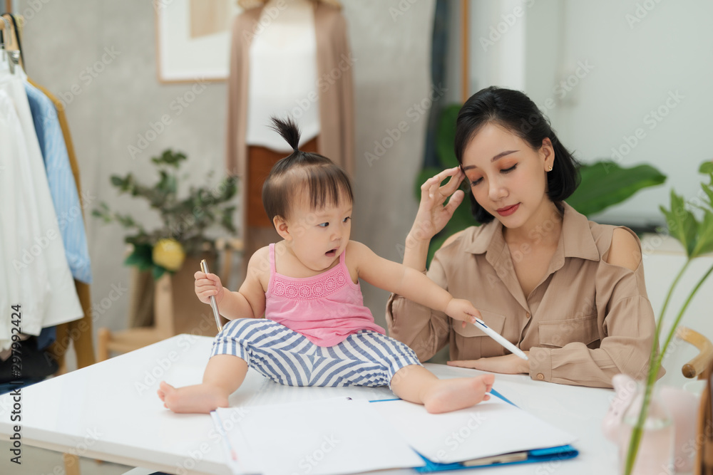 我妈妈真是个专家！小女婴坐在办公桌上看着相机