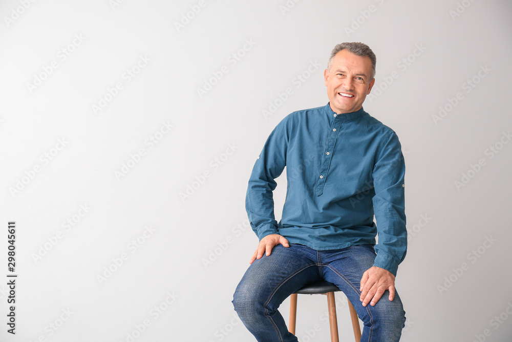 Portrait of stylish mature man on light background