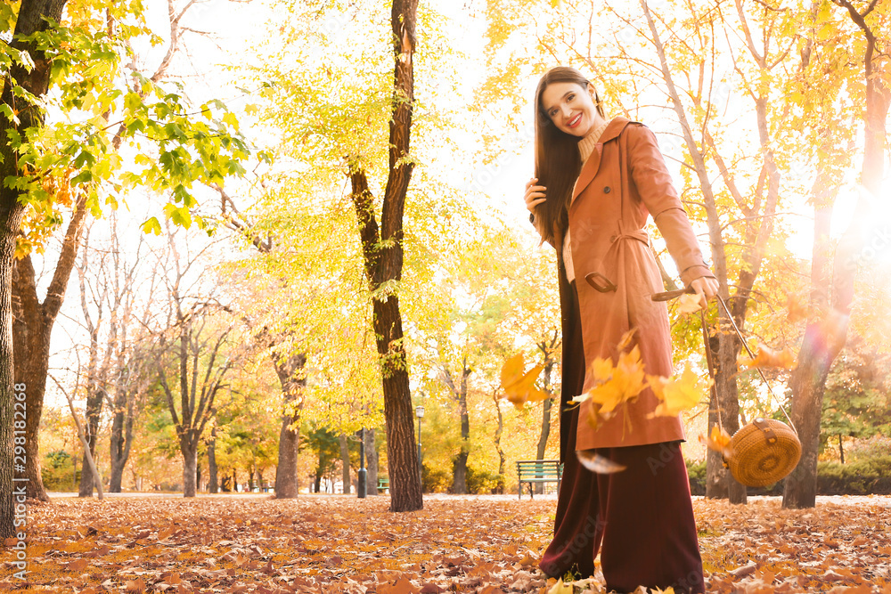 Beautiful fashionable woman in autumn park