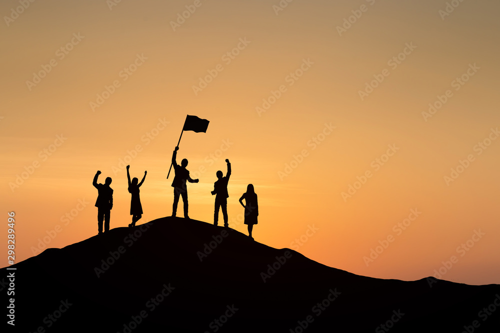 Silhouette of people are celebrating success at the top of the mountain, sky and sun light backgroun