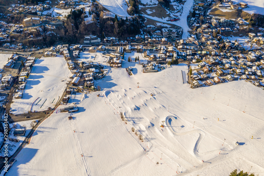 Stylish snow park in Alpine mountains ski resort. Snowboarders and skiers riding down the slides and