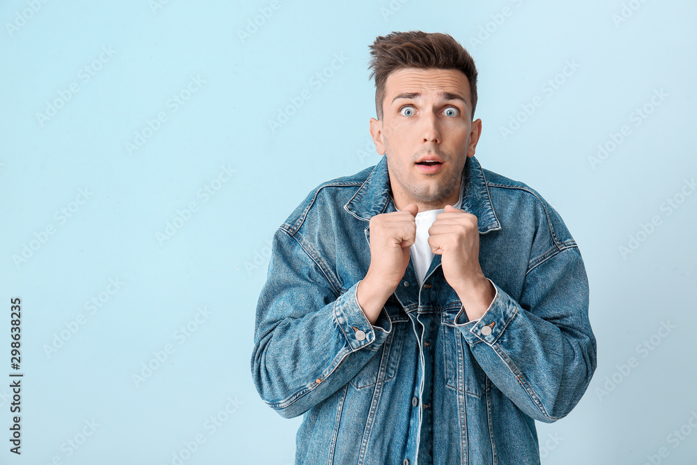 Shocked young man on color background