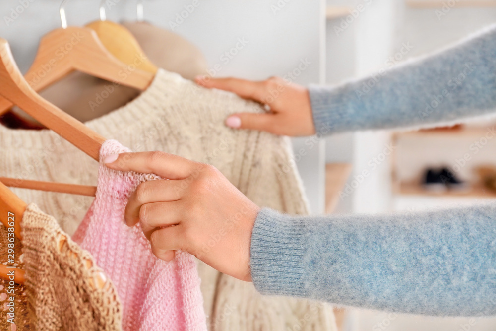 女人在更衣室的衣柜里挑选衣服，特写