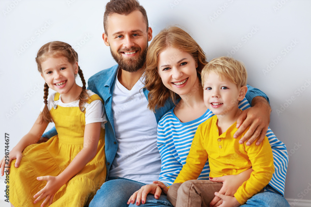 happy family mother father and children daughter and son  near an   grey blank wall.