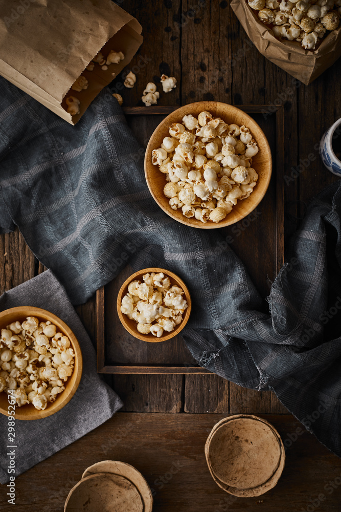 Delicious popcorn with caramel on wooden background..