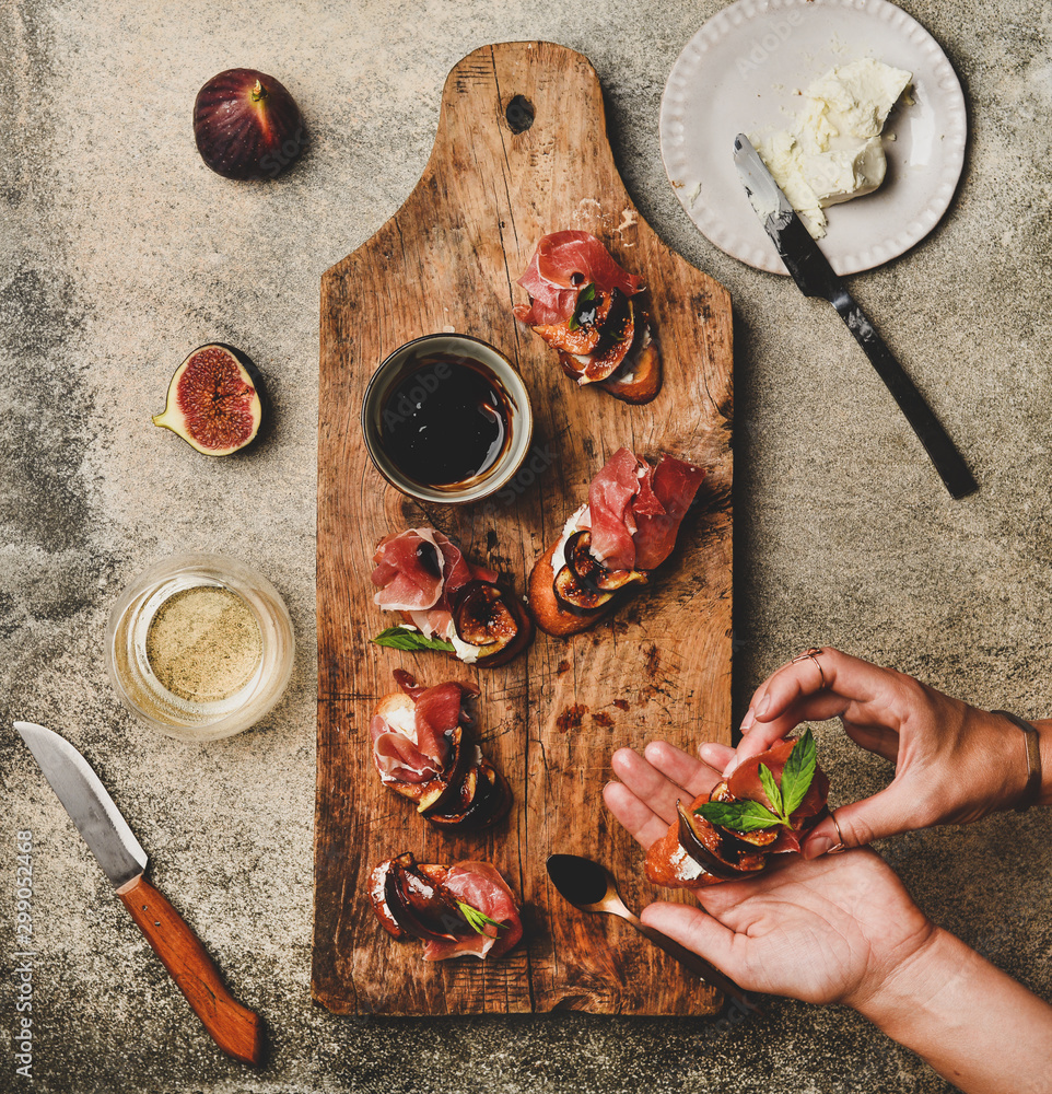 Party or catering food. Flat-lay of crostini with prosciutto, goat cheese and grilled figs on rustic