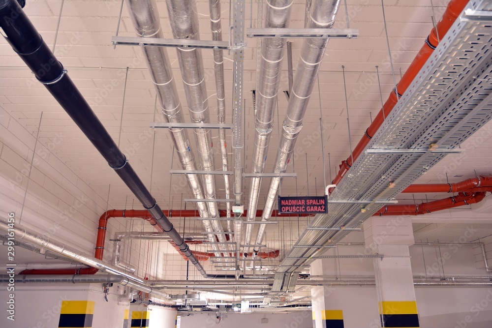 Water pipes and cable trays run under ceiling of a building