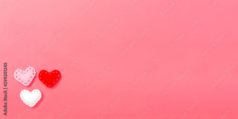 Heart cushions in Valentines day theme on a pink paper background