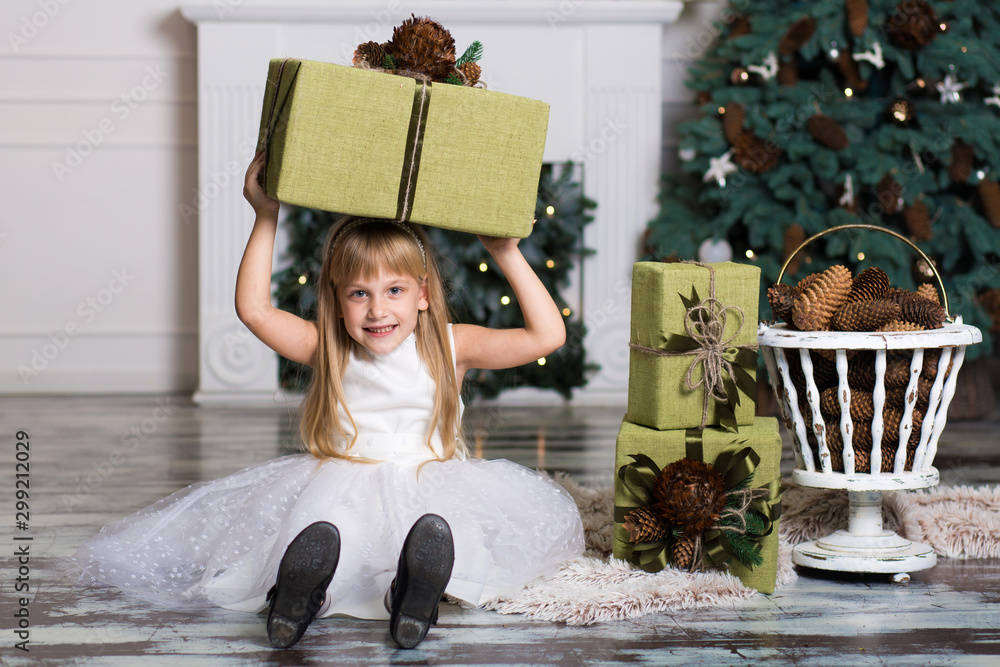 Happy girl holding a big box with a gift over her head. winter holidays, christmas and people concep