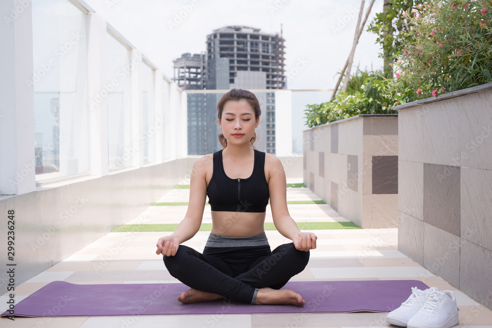 Woman on a yoga mat to relax outdoor.