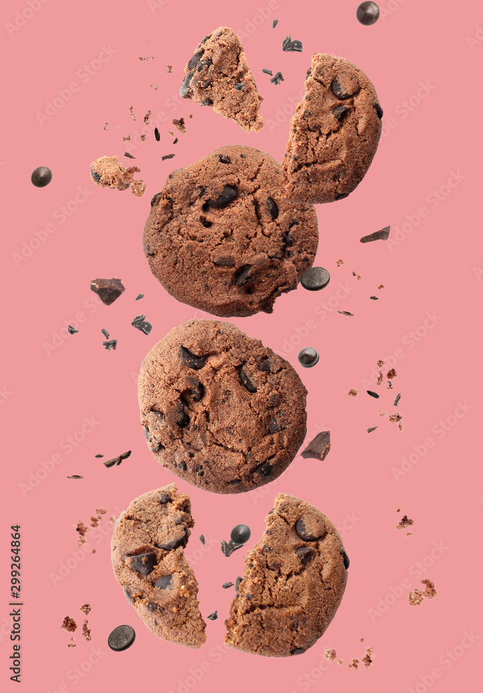 Falling chocolate cookies on color background