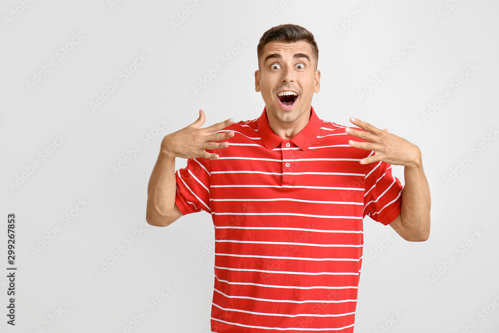 Surprised young man on light background